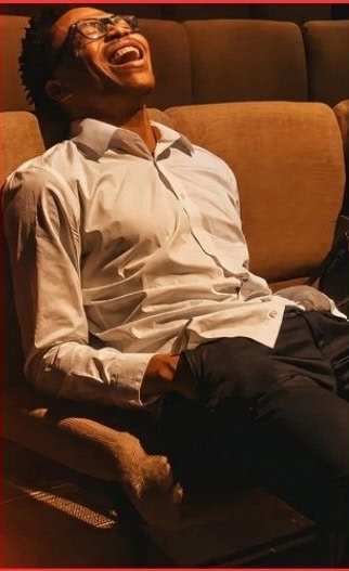 A man laughing joyfully while seated during a church service.